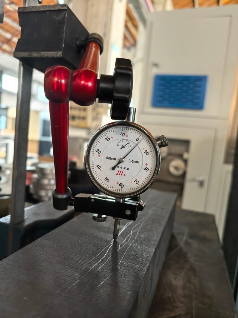 Graphite Cutting Solution Dial indicator measuring flatness along the 500 mm face after isostatic graphite block cutting